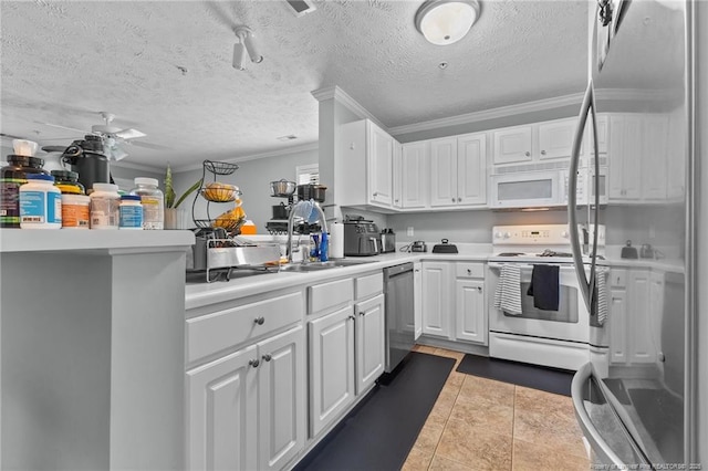 kitchen with white appliances, a sink, crown molding, white cabinetry, and light countertops
