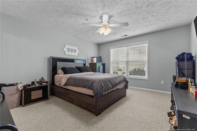 carpeted bedroom featuring a textured ceiling, baseboards, and ceiling fan