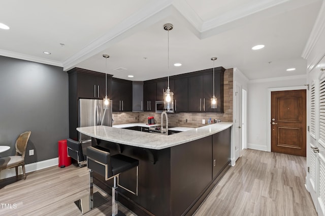 710 Independence Pl Unit 103, Raleigh, NC 27603 - kitchen featuring baseboards, tasteful backsplash, light stone counters, a peninsula, and ornamental molding