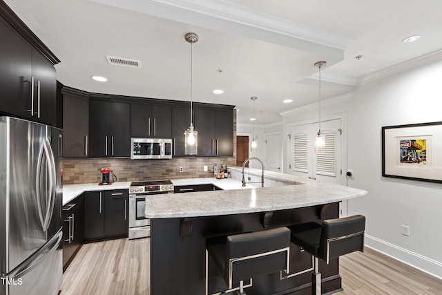 710 Independence Pl Unit 103, Raleigh, NC 27603 - kitchen featuring stainless steel appliances, light wood-style floors, backsplash, a breakfast bar, and crown molding