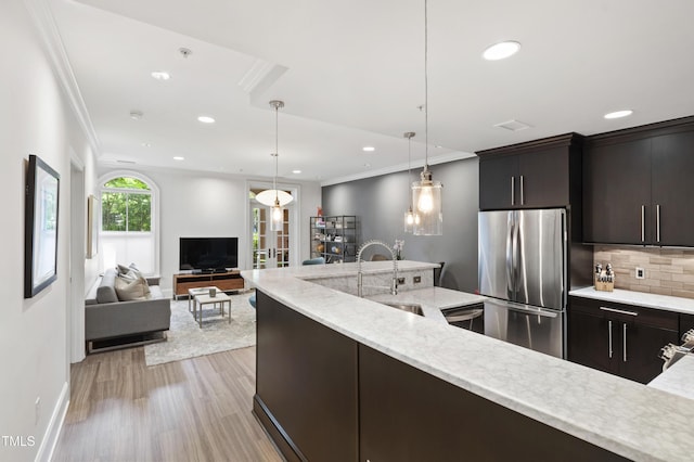 710 Independence Pl Unit 103, Raleigh, NC 27603 - kitchen with appliances with stainless steel finishes, a sink, ornamental molding, light wood-style floors, and backsplash
