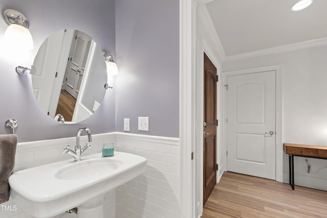 710 Independence Pl Unit 103, Raleigh, NC 27603 - bathroom with ornamental molding, a sink, a wainscoted wall, and wood finished floors