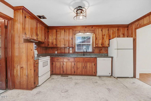 905 S 1st St, Smithfield, NC 27577 - kitchen with white appliances, a sink, dark countertops, brown cabinets, and wood walls