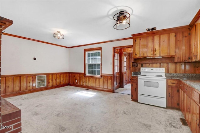 905 S 1st St, Smithfield, NC 27577 - kitchen featuring white electric stove, brown cabinets, a wainscoted wall, ornamental molding, and wooden walls
