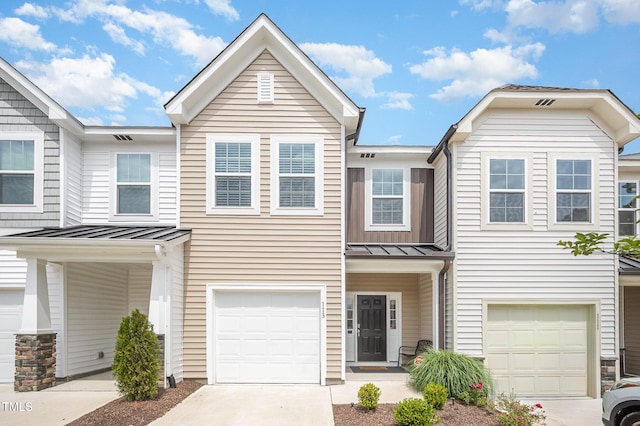113 Blandford St, Franklinton, NC 27525 - townhome / multi-family property featuring a standing seam roof, a garage, driveway, and metal roof
