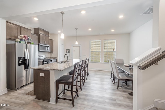 113 Blandford St, Franklinton, NC 27525 - kitchen with appliances with stainless steel finishes, a sink, baseboards, an island with sink, and a breakfast bar