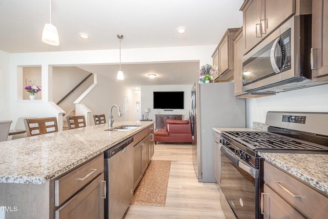 113 Blandford St, Franklinton, NC 27525 - kitchen with appliances with stainless steel finishes, a sink, light wood finished floors, and light stone counters