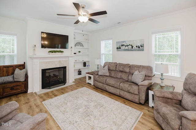 176 Lowery Ln, Benson, NC 27504 - living room featuring healthy amount of natural light, light wood finished floors, ornamental molding, ceiling fan, and a high end fireplace