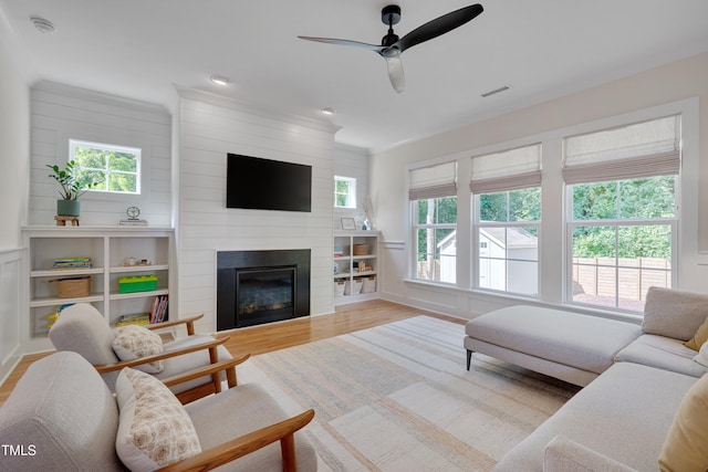 3003 University Dr, Durham, NC 27707 - living area with wood finished floors, a large fireplace, plenty of natural light, and a ceiling fan