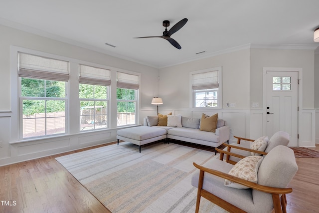 3003 University Dr, Durham, NC 27707 - living room featuring a ceiling fan, healthy amount of natural light, a decorative wall, light wood-style floors, and wainscoting