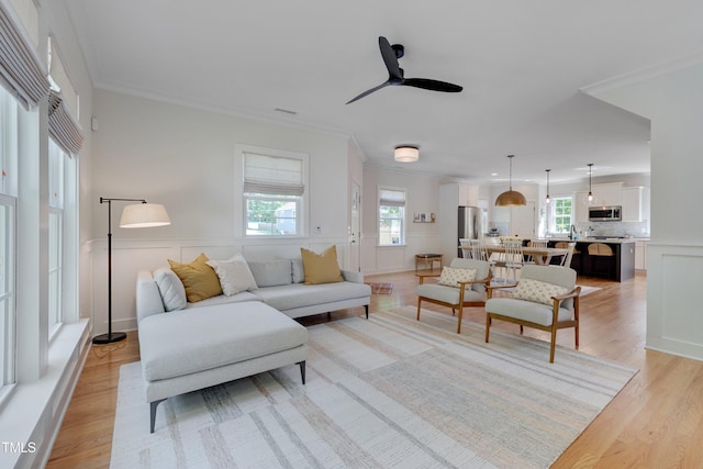 3003 University Dr, Durham, NC 27707 - living area with healthy amount of natural light, light wood finished floors, ceiling fan, crown molding, and wainscoting
