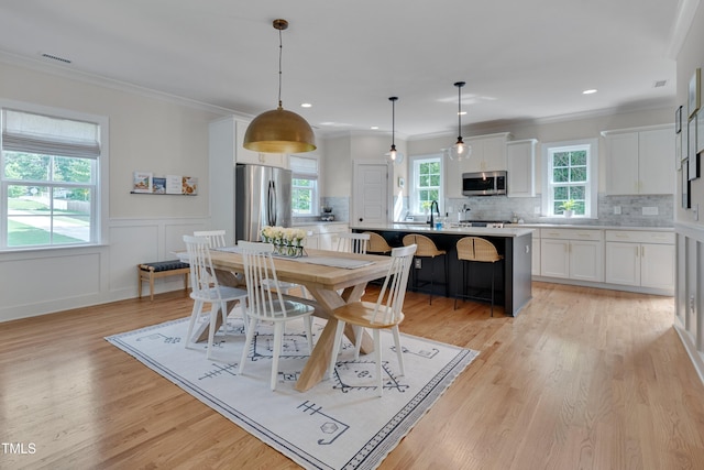 3003 University Dr, Durham, NC 27707 - dining space with light wood-style flooring, crown molding, recessed lighting, and a wainscoted wall