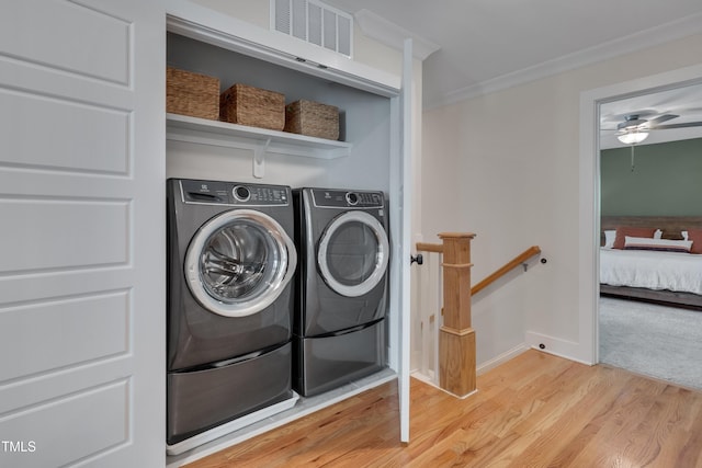 3003 University Dr, Durham, NC 27707 - laundry room featuring light wood finished floors, washing machine and clothes dryer, ceiling fan, baseboards, and crown molding