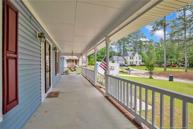 porch with a residential view and a lawn