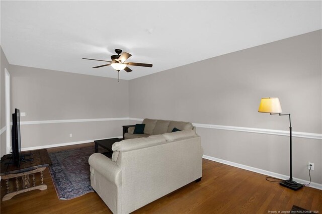 living room featuring ceiling fan, wood finished floors, and baseboards