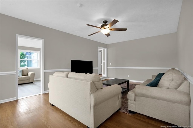 living area featuring ceiling fan, wood finished floors, and baseboards