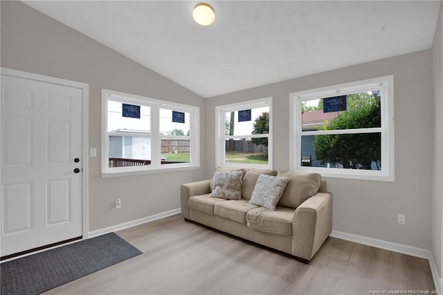 living area with lofted ceiling, light wood-style flooring, and baseboards