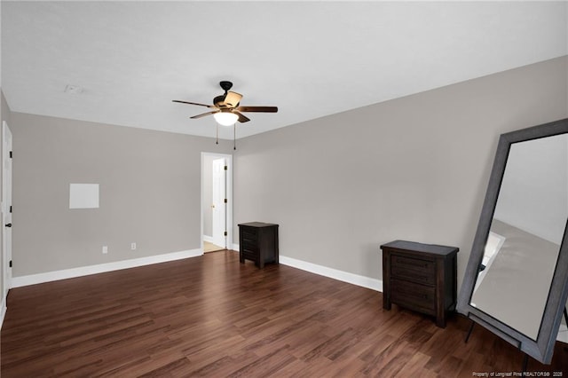 unfurnished room featuring ceiling fan, wood finished floors, and baseboards