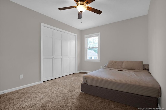 carpeted bedroom featuring baseboards, a closet, and a ceiling fan