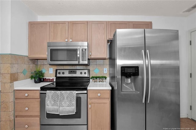 kitchen with stainless steel appliances, light countertops, and tasteful backsplash