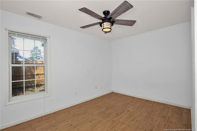 spare room with wood finished floors, baseboards, and a ceiling fan