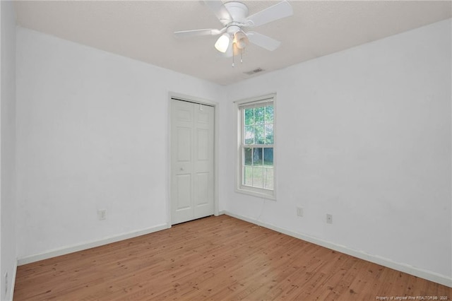unfurnished room featuring light wood finished floors, baseboards, and ceiling fan