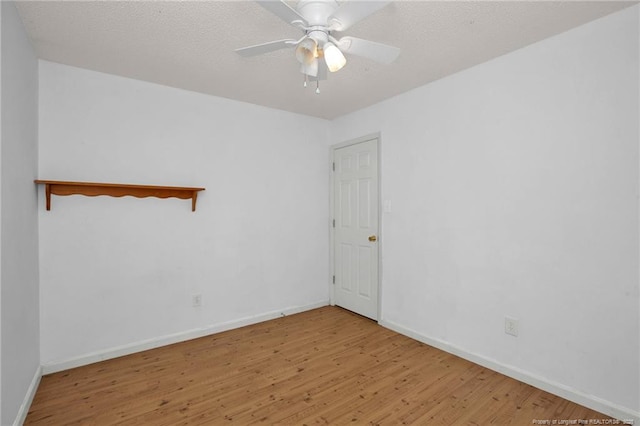 empty room with wood finished floors, baseboards, and a ceiling fan