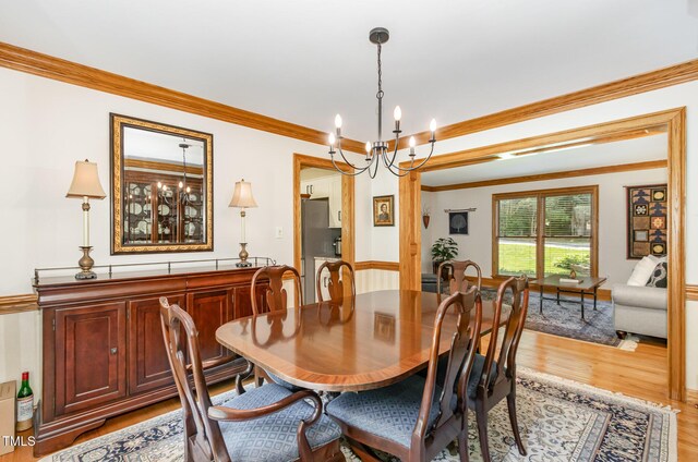 108 Hanover Pl, Chapel Hill, NC 27516 - dining room featuring light wood finished floors, crown molding, and a chandelier