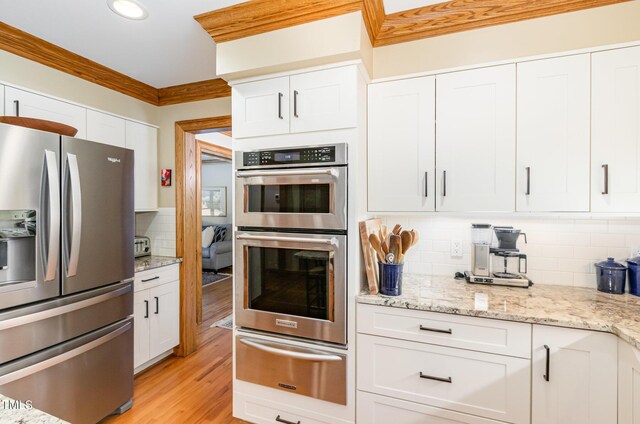 108 Hanover Pl, Chapel Hill, NC 27516 - kitchen with appliances with stainless steel finishes, a warming drawer, backsplash, white cabinetry, and light wood-style flooring