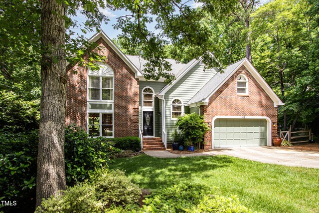 108 Hanover Pl, Chapel Hill, NC 27516 - traditional-style house with brick siding, concrete driveway, a front lawn, and a garage