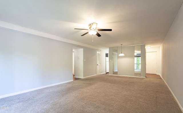 spare room featuring ceiling fan, dark carpet, and baseboards