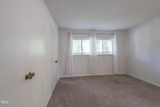 unfurnished bedroom featuring carpet and baseboards
