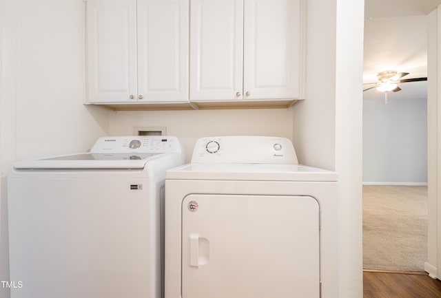 laundry area featuring independent washer and dryer, cabinet space, baseboards, and wood finished floors