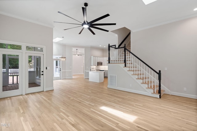 12301 Hardee Rd, Raleigh, NC 27614 - unfurnished living room featuring a ceiling fan, crown molding, light wood finished floors, stairs, and a high ceiling
