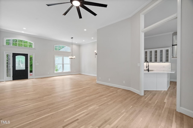 12301 Hardee Rd, Raleigh, NC 27614 - unfurnished living room featuring crown molding, light wood finished floors, a sink, ceiling fan, and baseboards