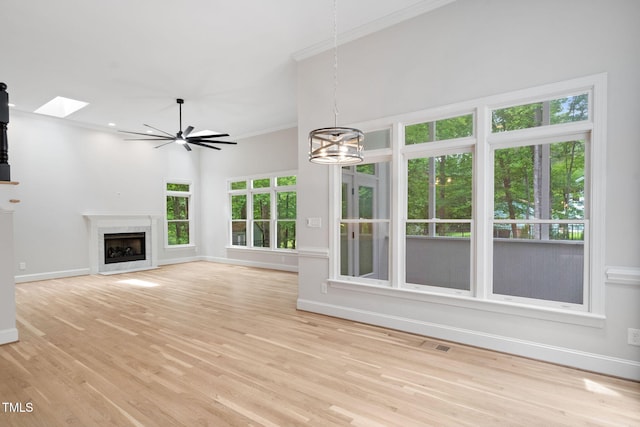 12301 Hardee Rd, Raleigh, NC 27614 - unfurnished living room with a skylight, baseboards, a chandelier, light wood-style floors, and ornamental molding