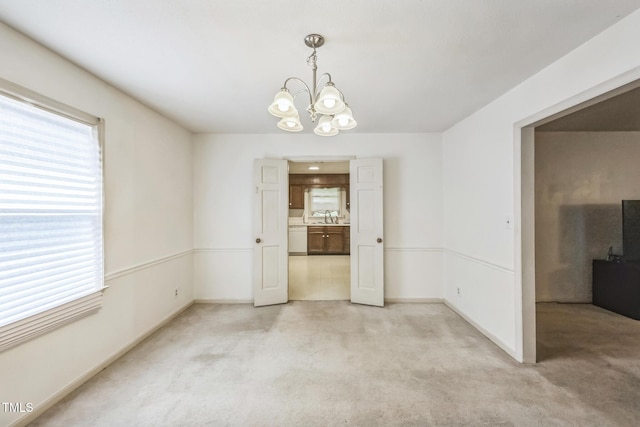 4407 Bromley Dr, Greensboro, NC 27406 - unfurnished dining area featuring a chandelier, light colored carpet, a sink, and baseboards