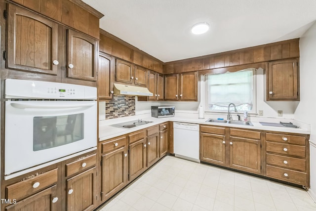 4407 Bromley Dr, Greensboro, NC 27406 - kitchen featuring white appliances, a sink, light countertops, under cabinet range hood, and backsplash