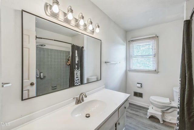 4407 Bromley Dr, Greensboro, NC 27406 - bathroom featuring toilet, wood finished floors, vanity, and curtained shower