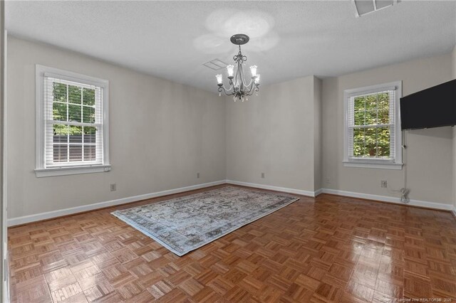 2190 Keith Hills Rd, Lillington, NC 27546 - unfurnished room with a chandelier, healthy amount of natural light, a textured ceiling, and baseboards