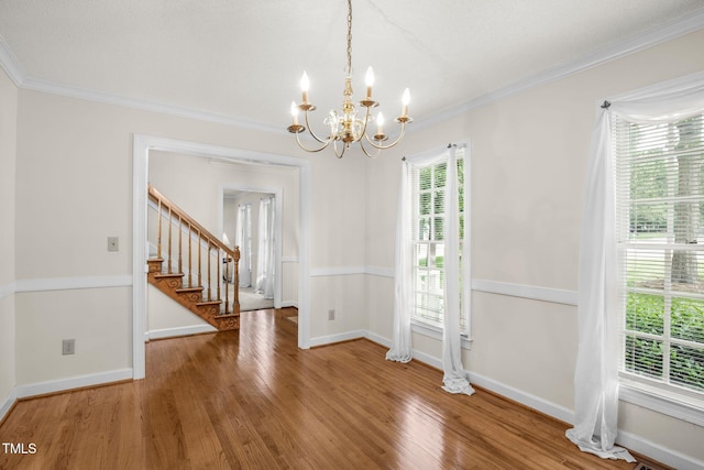 1113 Smokewood Dr, Apex, NC 27502 - unfurnished dining area featuring a chandelier, wood finished floors, stairs, crown molding, and baseboards