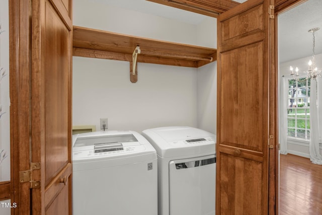 1113 Smokewood Dr, Apex, NC 27502 - laundry area with washer and clothes dryer, a chandelier, and wood finished floors