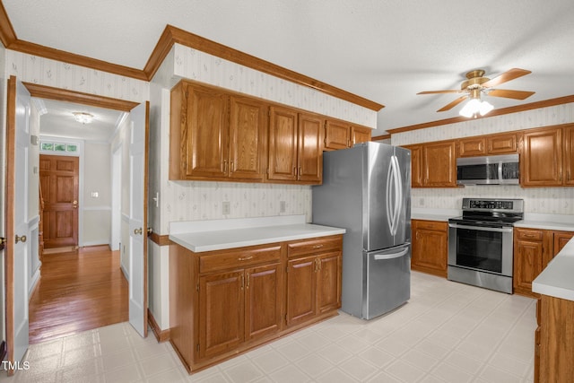 1113 Smokewood Dr, Apex, NC 27502 - kitchen with appliances with stainless steel finishes, crown molding, light flooring, ceiling fan, and wallpapered walls