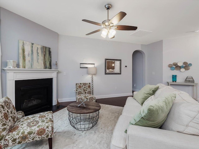 136 Shadow Hawk Dr, Durham, NC 27713 - living room featuring arched walkways, baseboards, a ceiling fan, a fireplace, and wood finished floors