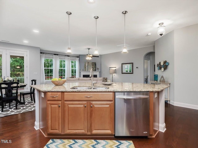 136 Shadow Hawk Dr, Durham, NC 27713 - kitchen with stainless steel dishwasher, a sink, arched walkways, an island with sink, and light stone counters