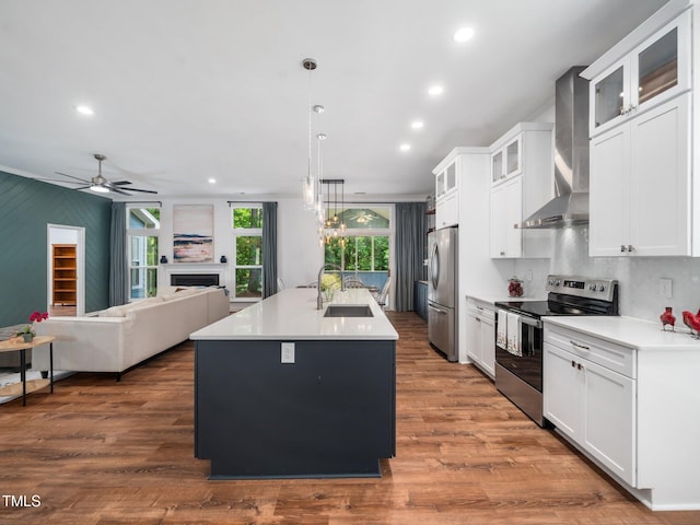 3400 Appling Way, Durham, NC 27703 - kitchen featuring appliances with stainless steel finishes, wall chimney exhaust hood, a kitchen island with sink, recessed lighting, and open floor plan
