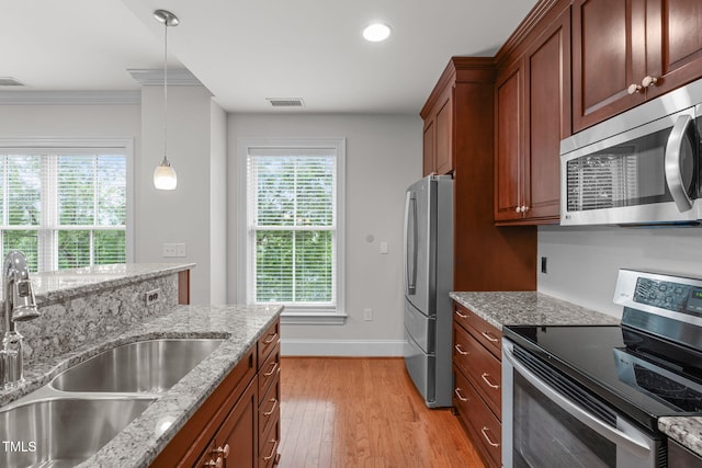 710 Independence Pl Unit 301, Raleigh, NC 27603 - kitchen with stainless steel appliances, a sink, light wood-style floors, baseboards, and healthy amount of natural light