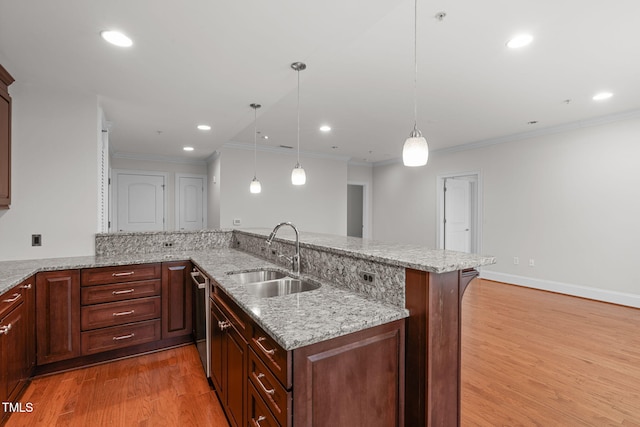 710 Independence Pl Unit 301, Raleigh, NC 27603 - kitchen featuring a sink, light wood finished floors, stainless steel dishwasher, a peninsula, and light stone countertops