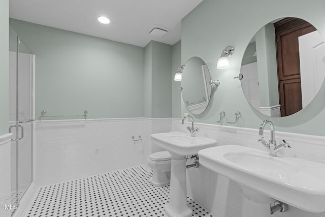 710 Independence Pl Unit 301, Raleigh, NC 27603 - full bathroom with a sink, a wainscoted wall, toilet, a shower stall, and tile walls