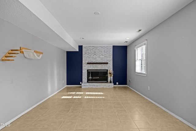 1195 Champion Dr, Cary, NC 27511 - unfurnished living room with a textured ceiling, a brick fireplace, light tile patterned floors, and baseboards